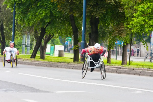 KRAKOW, POLAND - MAY 28 : Cracovia Marathon. Unidentified handicapped man in  marathon on a wheelchair on the city streets on May 18, 2014 in Krakow, POLAND