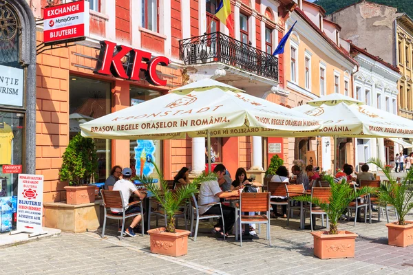 BRASOV, ROMANIA - JULY 15: Council Square on July 15, 2014 in Brasov, Romania. People buying fried chicken at local Kentucky Fried Chicken Restaurant.