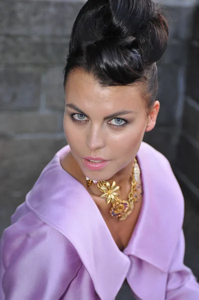 portrait of fashion model wearing pink dress and gold jewelry