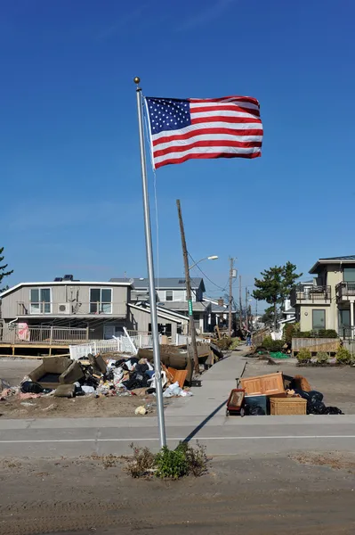 NEW YORK, NY - NOVEMBER 09: An American flag flies from the front yard of a house in a damaged area November 9, 2012 in the Breezy Point part of Far Rockaway in the Queens borough of NY.