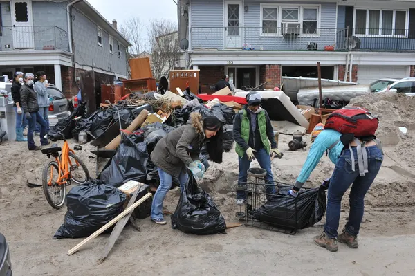 QUEENS, NY - NOVEMBER 11: Volunteers cleaning debris and sand in the Rockaway beach residential area from Hurricane Sandy in Queens, New York, U.S., on November 11, 2012.