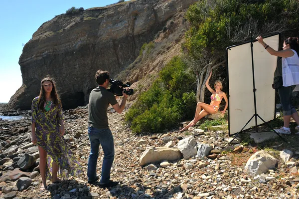Photo video crew on location set with bikini models