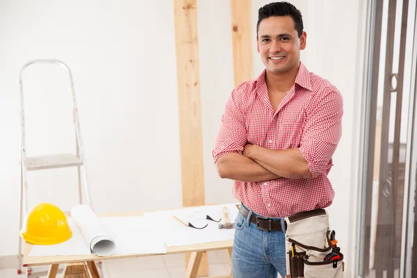 Portrait of an attractive young contractor working at a house and smiling