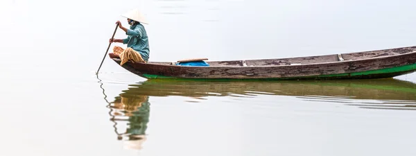 Woman on wooden boat in river