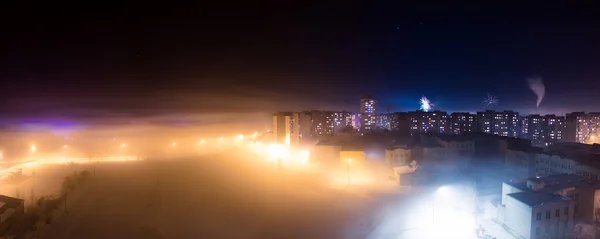 Night city in the winter fog