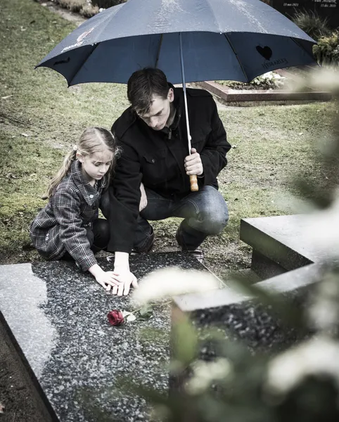 Father and daughter at graveyard