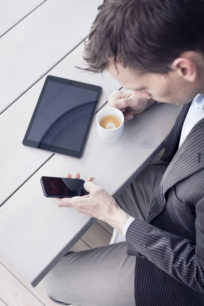 Businessman using tablet pc and smartphone.