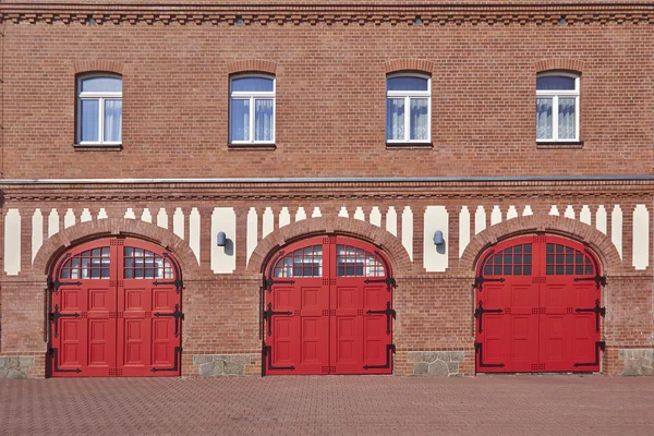Three red doors and four windows, firesquad station, central Europe