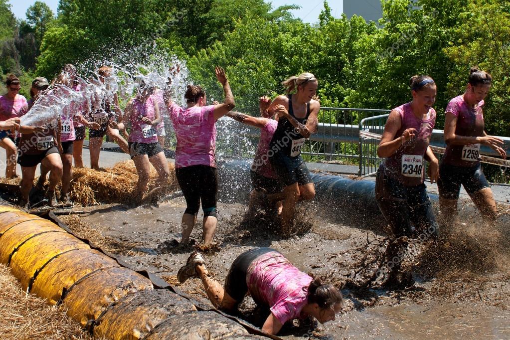 Women Get Hosed Down Running Through Obstacle Course Mud Pit Stock Women Get Hosed Down Running Through Obstacle Course Mud Pit Stock