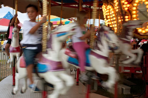 Motion Blur Of Kids Riding Carousel At Fair