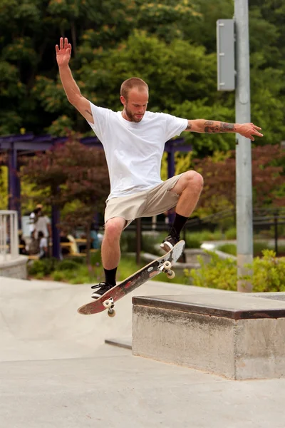 Man Practices Skateboard Trick At Park