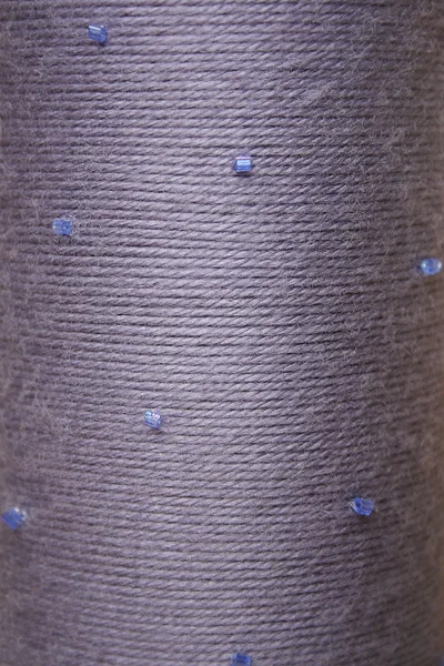Round texture of grey woolen threads with beads