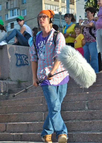 Filming team member holds a big microphone in his hands