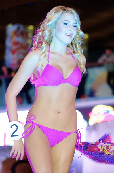 Blond girl dances in pink bikini