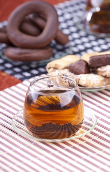 Cup of black tea in front on cookies