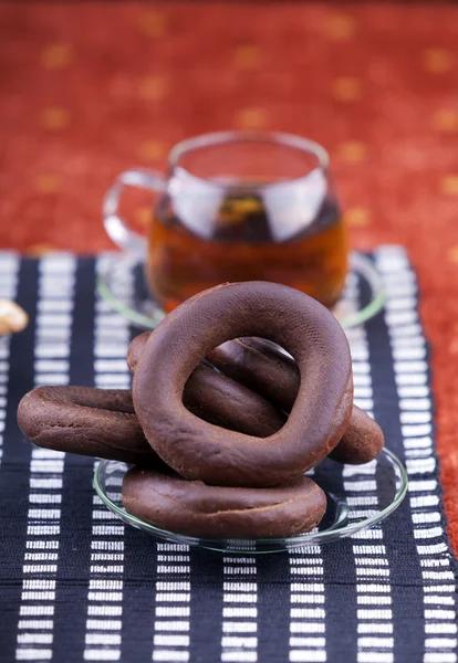 Plate with pretzel next to a cup of tea