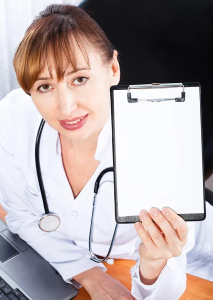 Female doctor showing blank clipboard