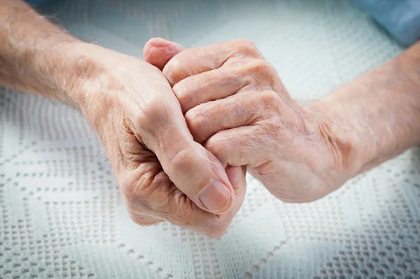 Care is at home of elderly. Old people holding hands.