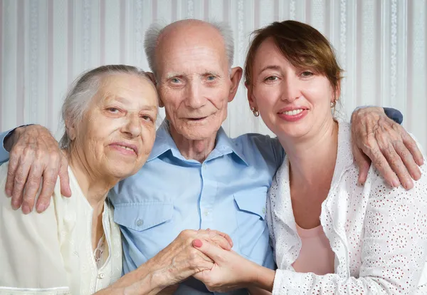 Senior man, woman with their caregiver at home.