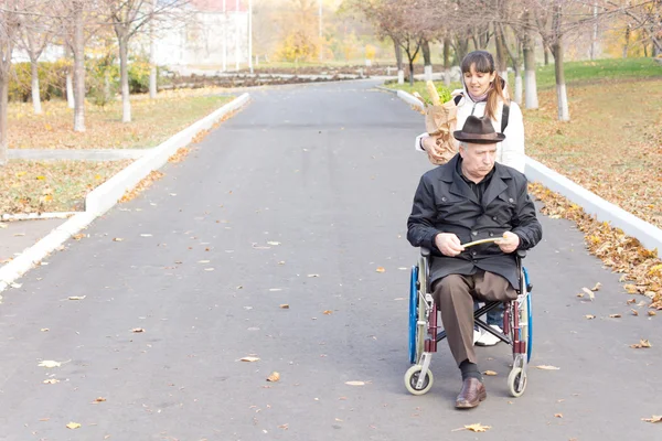 Carer helping a disabled man in a wheelchair