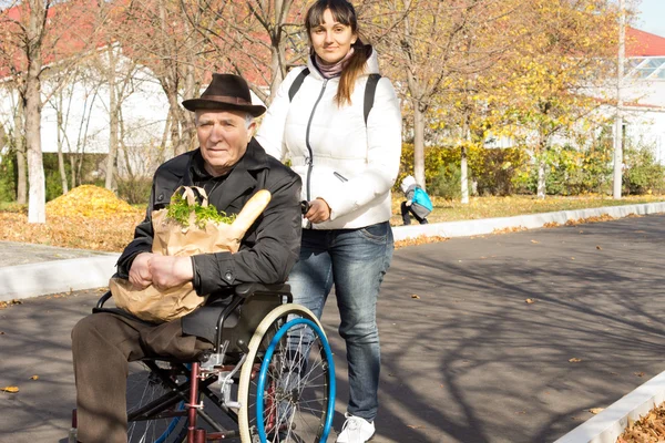 Woman helping her senior handicapped father