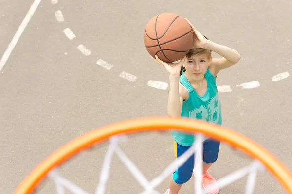 Girl taking aim at the goal on a basketball court