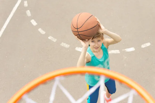 Teenage girl playing basketball