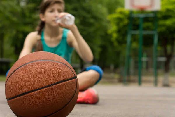 Young basketball player drinking water