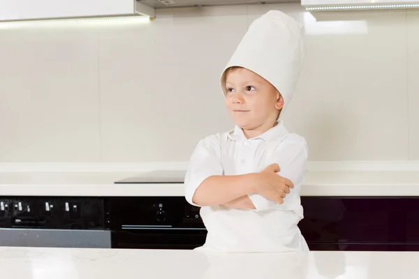 Confident smiling young boy in a chefs uniform