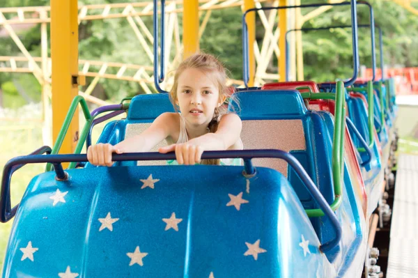 Little girl sitting on a fairground ride