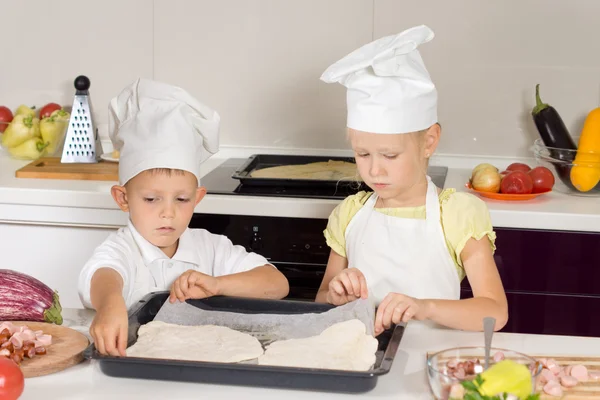 Little boy and girl making homemade pizza