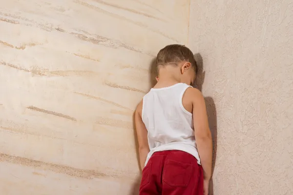 Little Young Boy Facing Wooden Wall