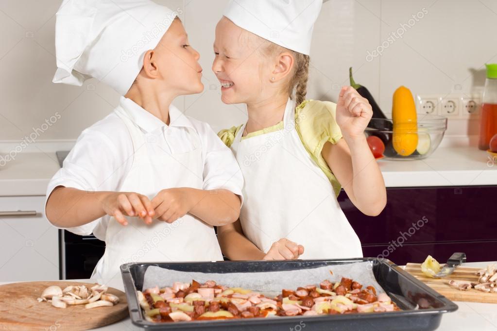 Schattige kleine chef kok kussen van haar zus chef kok — stockfoto ...