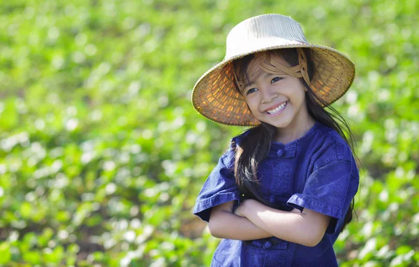 Little smiling girl farmer on green fields