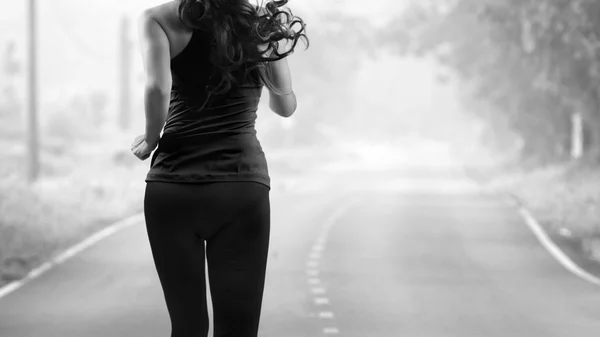 Rear view of woman jogging on the road