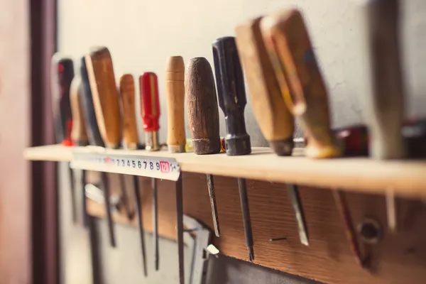 Old woodworking tools on wall, retro tinted