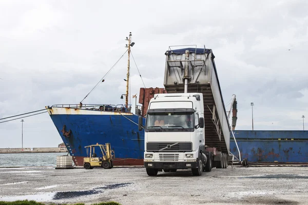 Truck loading grain on ship