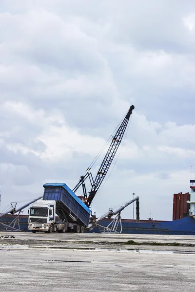 Truck loading grain on ship