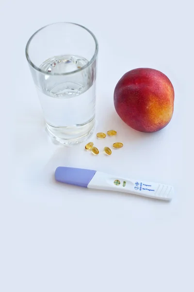 Pregnancy test, pills, fruit