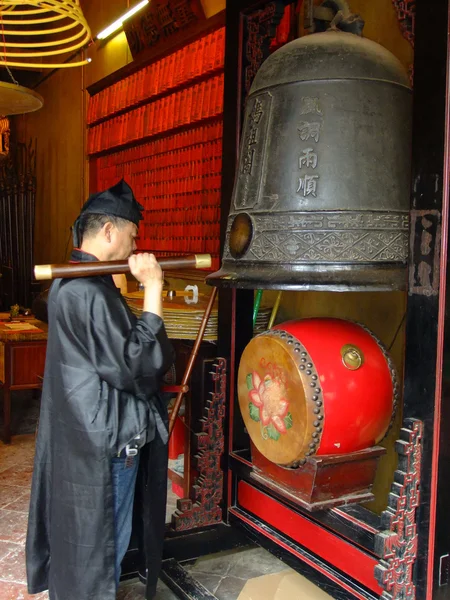 Taoist priest hitting temple bell, A-Ma temple, Macau