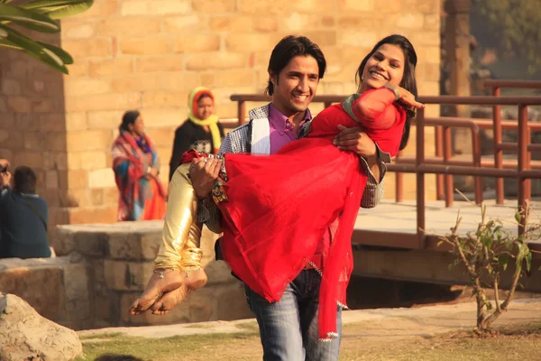 Indian man carrying indian woman at Qutub Minar complex, Delhi