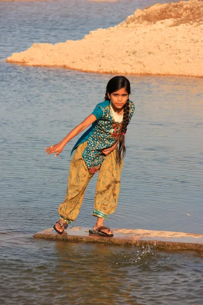 Local girl playing near water reservoir, Khichan village, India