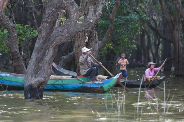 Unidentified people rowing boat on Tonle Sap Lake in Siem Reap, Cambodia