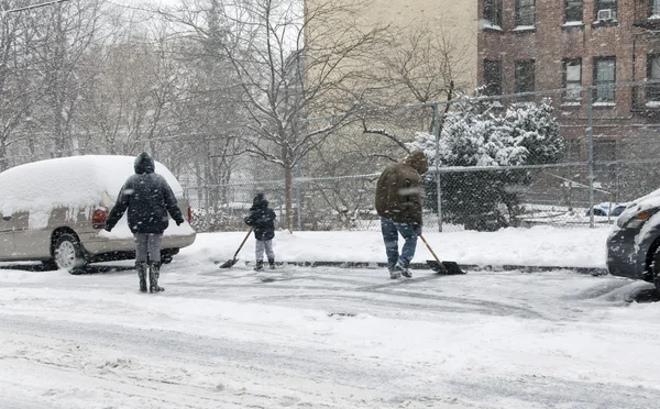 Family shoveling during snow storm in New York