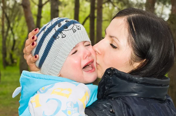 Portrait of a crying child in mother\'s arms