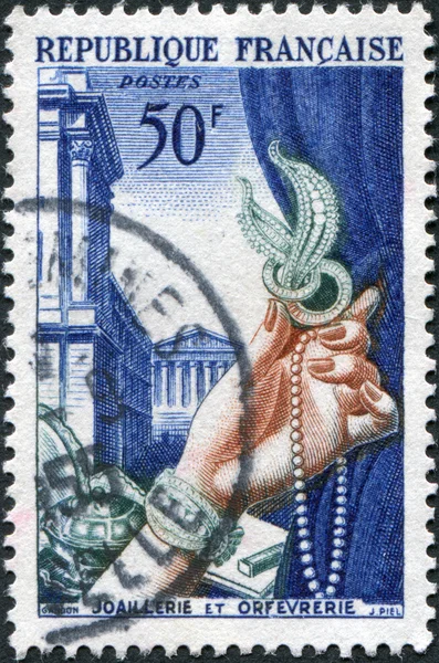 A stamp printed in France, is dedicated to industry exports is shown Jewelry and metalsmith\'s work, in the background, Rue Royale, circa 1954