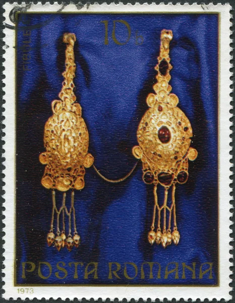 ROMANIA - CIRCA 1973: A stamp printed in the Romania, shows the gold jewelery from Pietroasa, Fibulae (brooch), circa 1973