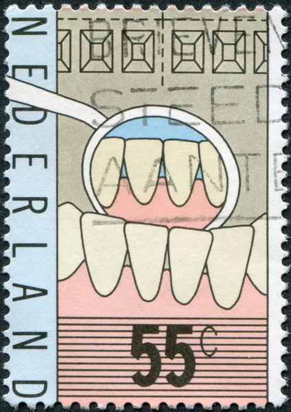 NETHERLANDS - CIRCA 1977: A stamp printed in the Netherlands, is dedicated to the 100th anniversary of the teaching of dentists, is shown Teeth, Mirror of Dentist, c