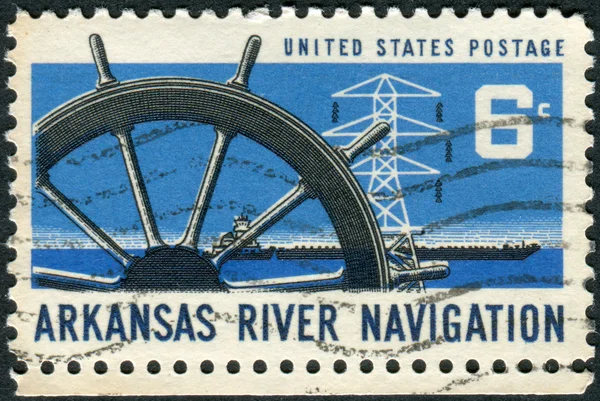 Postage stamp printed in USA, dedicated to the Opening of the Arkansas River to commercial navigation, shows Ship\'s Wheel, Power Transmission Tower & Barge