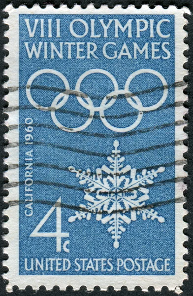 A postage stamp printed in the USA, dedicated to the Opening of the 8th Olympic Winter Games, Squaw Valley, shows the Olympic Rings and Snowflake